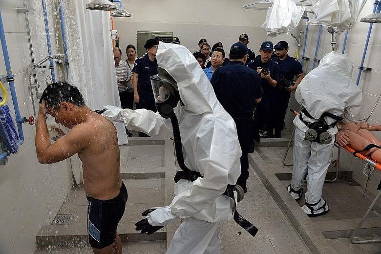 Above: Mr Desmond Lee (in light blue), Senior Minister of State, Ministry of Home Affairs and Ministry of National Development, and members of the public visiting a decontamination chamber in the Bukit Panjang MRT shelter yesterday. Such chambers are