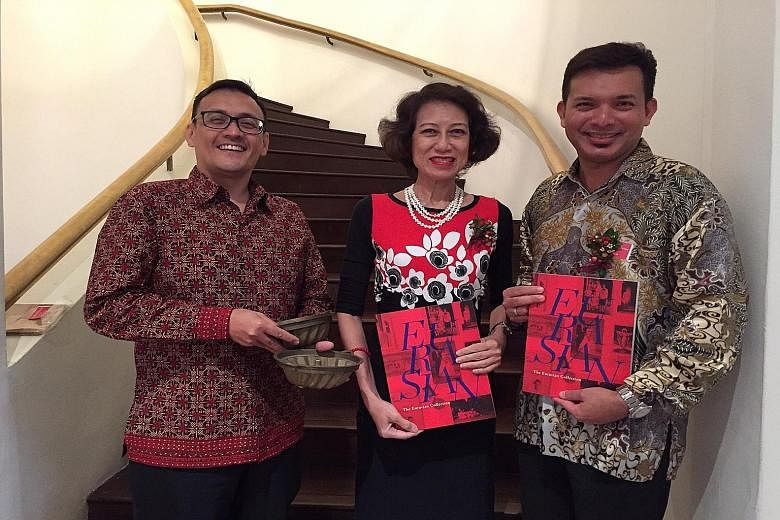Artefact donors (from left) John Conceicao, Gerardine Donough-Tan and Kevin Aeria with copies of the book, The Eurasian Collection, which was launched yesterday. Mr Conceicao is holding brass cake moulds used to bake breudher, a type of cake introduc