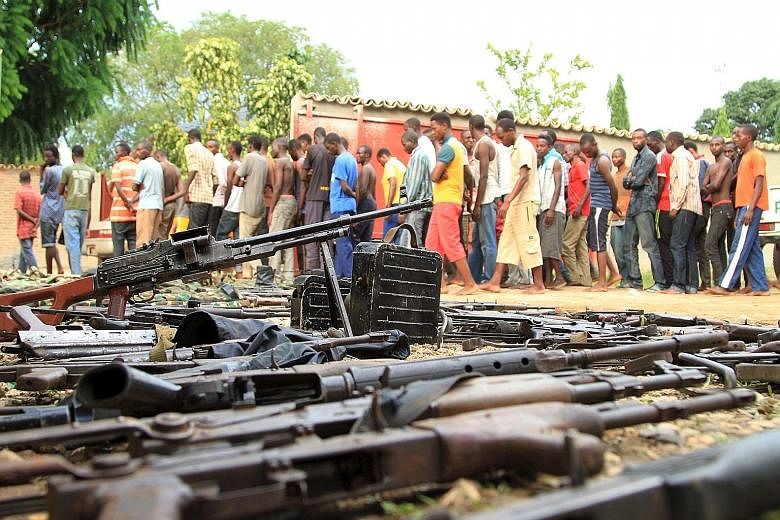 Suspected fighters being paraded before the media by Burundian police near a recovered cache of weapons after clashes in the capital Bujumbura last Saturday.