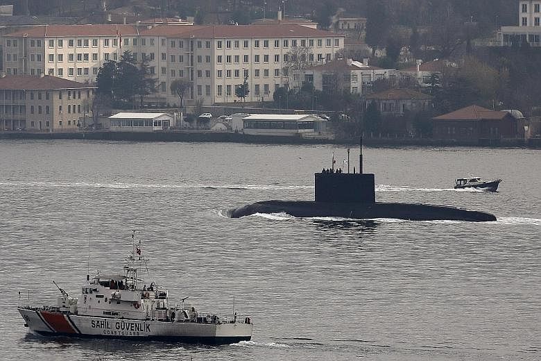 A Russian submarine being escorted by a Turkish Navy Coast Guard boat in the Bosphorus, on its way to the Black Sea, on Sunday. Yesterday, a Russian-run energy firm in Crimea said a Turkish vessel did not give way to a convoy of Russian ships, includ