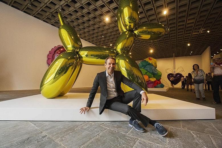 Artist Jeff Koons with his creation Balloon Dog (Yellow) in a 2014 photograph.