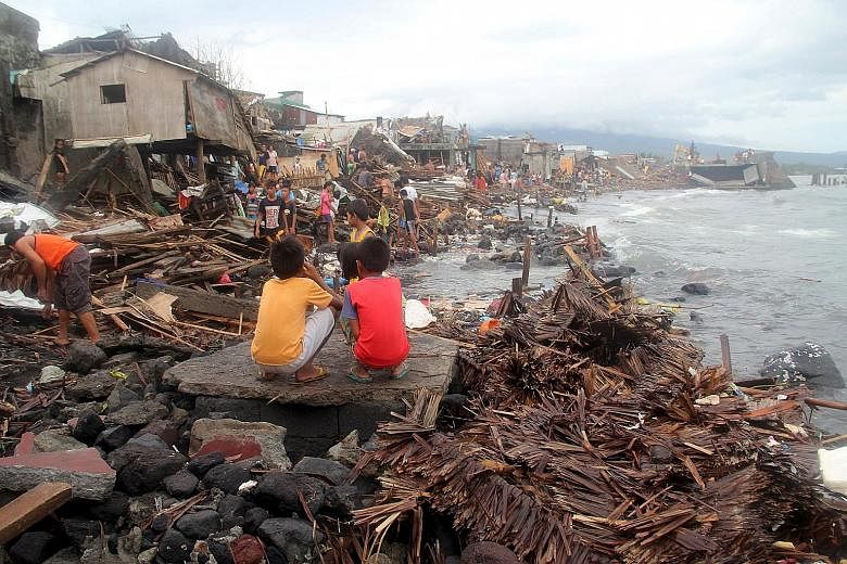Villagers surveying the devastation in the coastal village of Pigcale after Typhoon Melor swept through Legazpi city, in the Philippines' Albay province, yesterday. Four people were killed and millions were left without power after the typhoon barrel