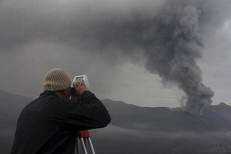 An officer from the observation post near Indonesia's Mount Bromo taking a reading of the physical size of the volcano during an eruption in Probolinggo, East Java, yesterday. Mount Bromo is one of the most popular tourist attractions in its region.