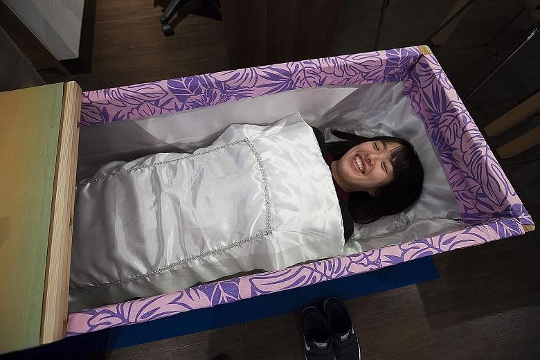 A participant at the Coffin Experience event in Tokyo, Japan, last month. A three-day industry expo earlier this month, the first of its sort, drew 220 companies exhibiting businesses related to death to more than 22,000 visitors.