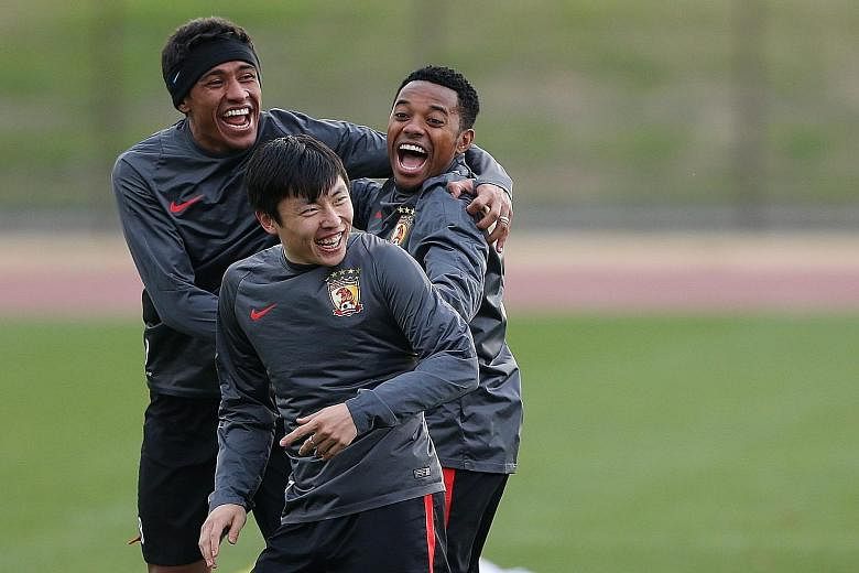 Guangzhou Evergrande's Brazilian connection Paulinho (left) and Robinho (right) laughing with Zheng Long during their training session in Yokohama ahead of their semi-final clash with Barcelona.