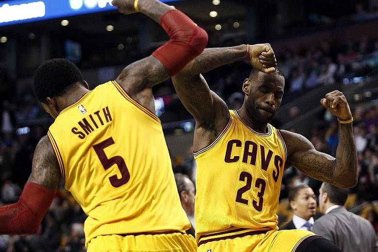 Cleveland Cavaliers forward LeBron James (right) and guard J.R. Smith celebrating against the Boston Celtics during the second half at TD Garden. The Cavs beat the Celtics 89-77.