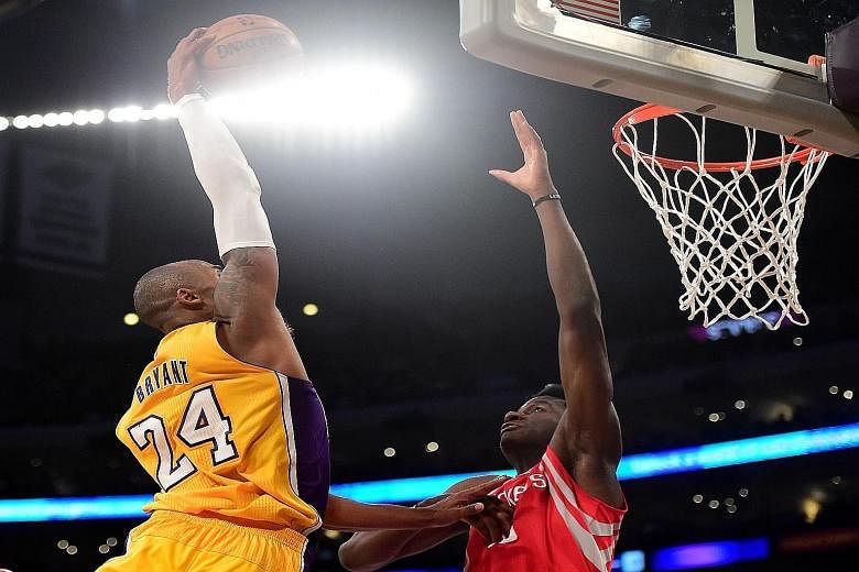 Kobe Bryant of the Los Angeles Lakers (left) dunking over Clint Capela of the Houston Rockets on Thursday. Bryant earned a huge ovation for the dunk - his first of the season - but the Rockets won 107-87.