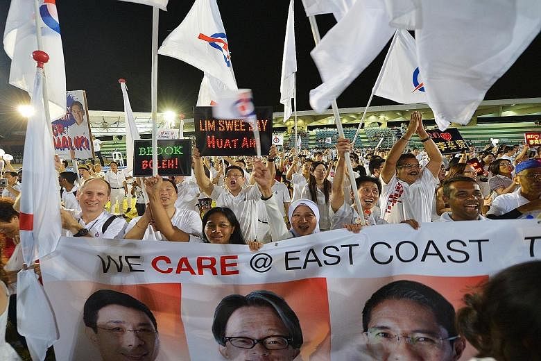 Jubilant PAP supporters with a poster of the East Coast GRC team, comprising Mr Lim Swee Say, Mr Lee Yi Shyan, Dr Mohamad Maliki Osman and Ms Jessica Tan, at Bedok Stadium in September. The GRC was one that some analysts had believed could be the nex