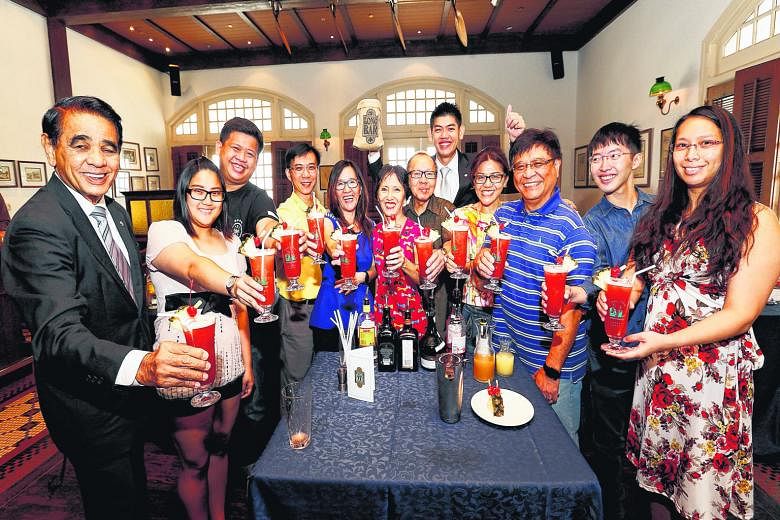 Raising a toast with their Singapore Slings in the Raffles Hotel Long Bar are (from left) Raffles Hotel resident historian Leslie Danker, 76; Ms Eunicia Tan, 22; Mr Gibson Chua, 25; Mr Gary Tan, 51; Ms Elin Loo, 49; Ms Irene Tan, 58; Mr Patrick Tan, 
