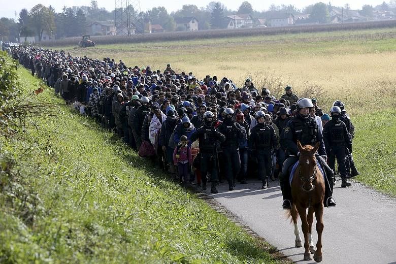 A mounted policeman leading a group of migrants near Dobova, Slovenia. The International Organisation for Migration said the number of refugees and migrants crossing the Mediterranean to Europe would likely exceed a million arrivals for the year in a
