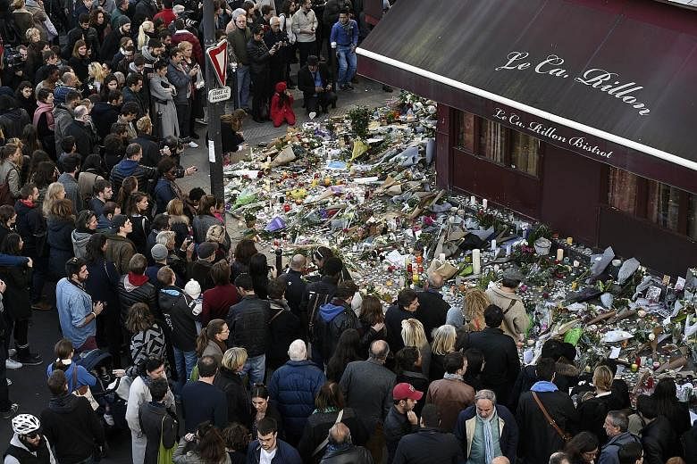 People gathering on Nov 16 for a memorial at a restaurant attacked by gunmen days earlier, in Paris.