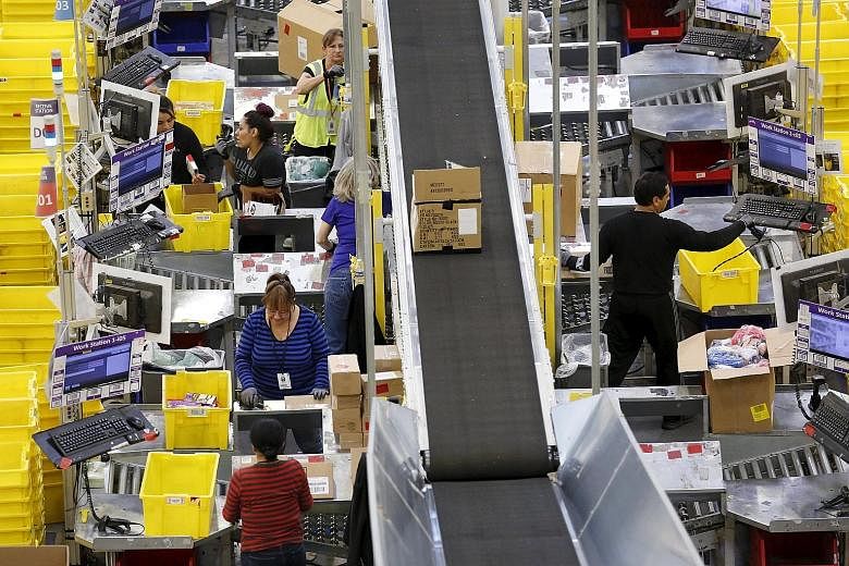 Workers prepare orders for customers at the Amazon Fulfilment Centre in Tracy, California. Despite a slow pace of economic recovery, the US labour market is showing all of the tightening that is typical of any previous rapid recovery.