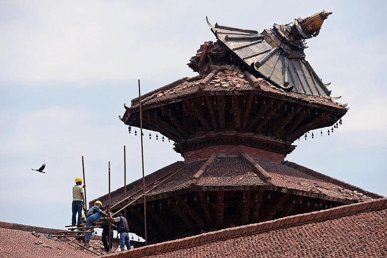 Workers reinforcing the roof of a temple in historical Durbar Square, in Nepal, which had collapsed, following an earthquake in April.
