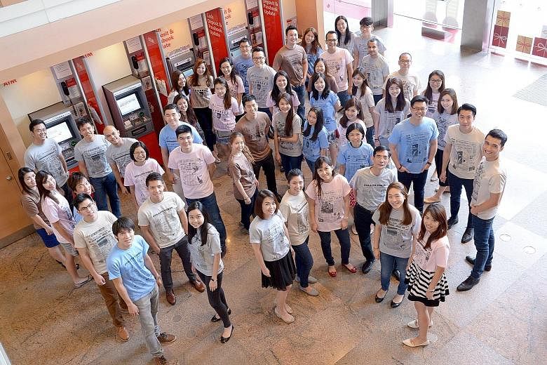 Fifty OCBC Bank employees (left) donned T-shirts produced by The Straits Times on Friday to commemorate the newspaper's 170th anniversary. The bank bought 200 T-shirts, which feature historical front pages of The Straits Times, for its staff voluntee