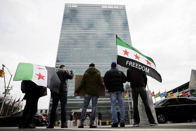 Protesters, some holding Syrian revolutionary flags, in front of the UN headquarters in New York on Friday. The UN Security Council resolution endorses a political transition to end the civil war in Syria.