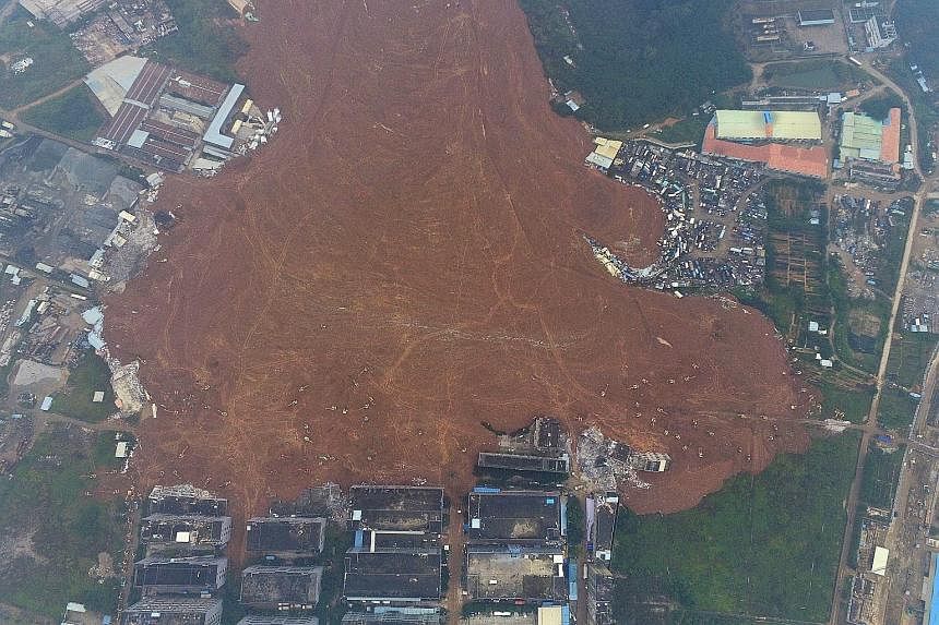 An aerial view taken yesterday showing the collapsed building brought down by Sunday's landslide in Shenzhen. The landslide is estimated to cover an area of 380,000 sq m - or about 50 football fields. Excavators have not reached the bottom of the sil