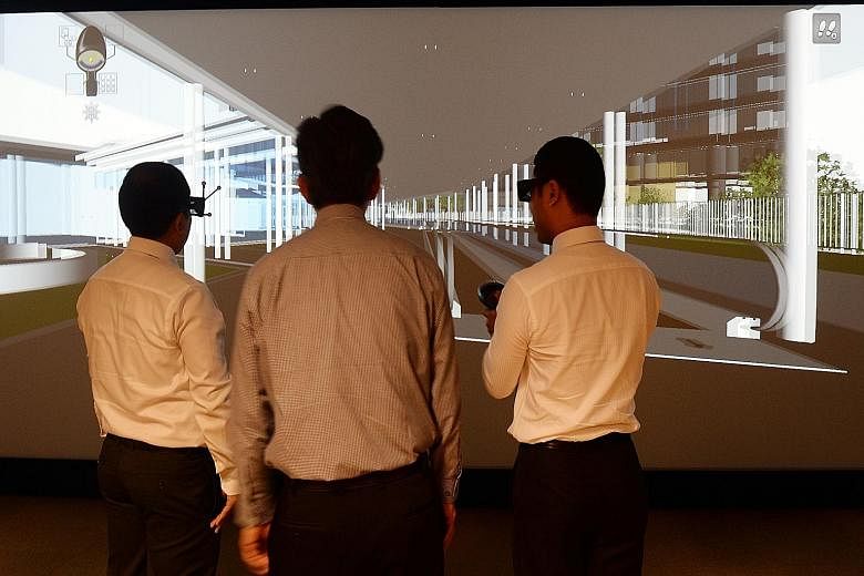 (From left) DCA Architects' BIM manager Min Thu, BCA chief John Keung and Senior Minister of State Desmond Lee taking a virtual tour of the upcoming Mapletree Business City II project at the new Centre for Lean and Virtual Construction yesterday.