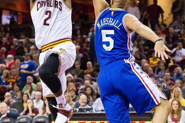 Kyrie Irving (left) of the Cleveland Cavaliers shooting over Kendall Marshall of the Philadelphia 76ers during the second half at Quicken Loans Arena on Sunday. The Cavaliers defeated the 76ers 108-86.
