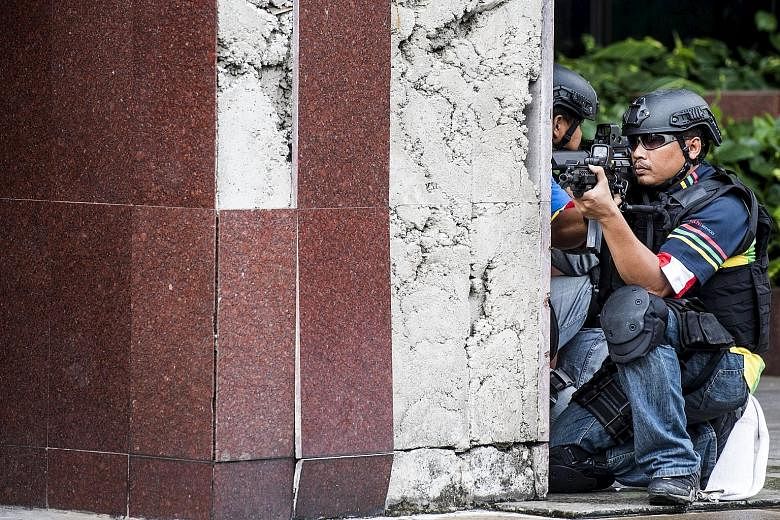 Police tape around a house (above) in Java raided by anti-terror forces on Sunday as Indonesia remains on high alert following the arrests of nine militants. Navy special forces (left) taking part in an anti-terror drill in Jakarta over the weekend.