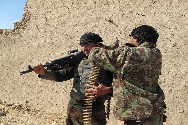 Afghan National Army soldiers adjusting their equipment in Helmand on Monday. The deputy governor of the province warned that the area was at risk of falling to the Taleban, but the government rejected such assertions and said reinforcements had been