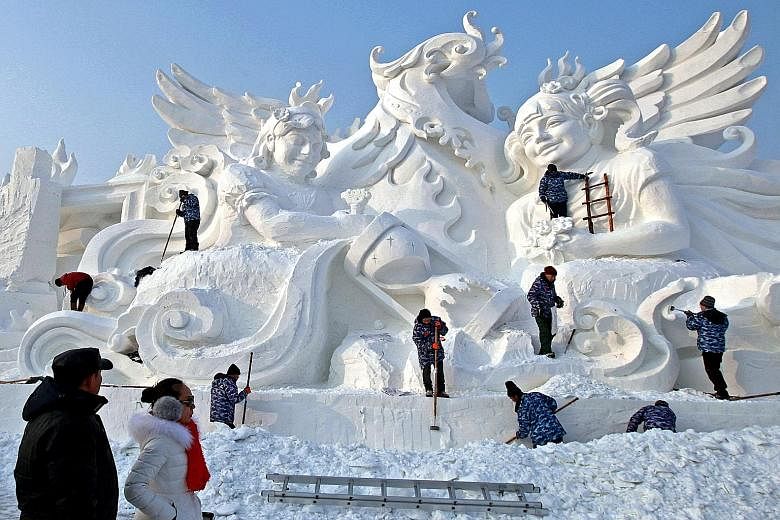 Artists chiselling away at a snow sculpture, which resembles a traditional marble work of art, at the annual International Snow Sculpture Art Expo in Harbin, Heilongjiang province, in China yesterday. Spectacular frozen works can be seen at this larg