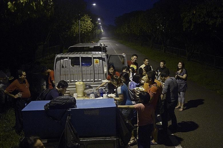Workers from a chicken farm in the Lim Chu Kang area tucking into traditional Myanmar and Karen fare such as beef curry and braised eel, provided by Karen Baptist Church members.