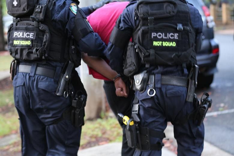 Sydney police with one of two men arrested during a counter-terrorism operation yesterday. A key Australian naval base is said to have been one of their targets.