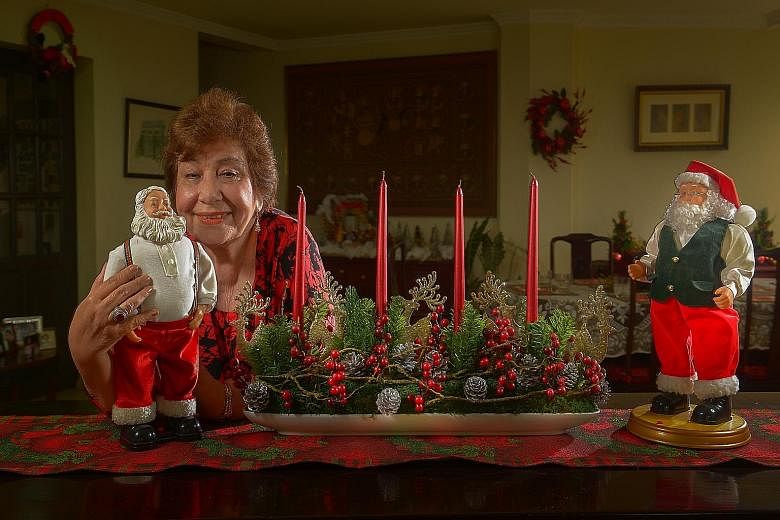 Retiree Dorothy Tessensohn at her Jervois Road apartment with her battery- powered dancing and chuckling Santa Claus figurines.