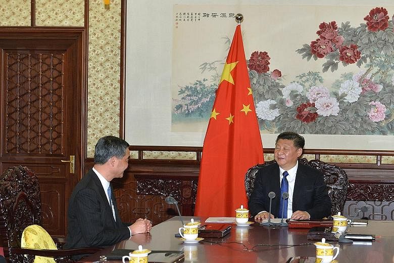 Hong Kong Chief Executive Leung Chun Ying (left), seated at one side of a conference table, during a meeting with Chinese President Xi Jinping in Beijing on Wednesday.