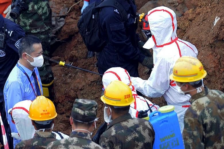 A medical personnel spraying disinfectant over a rescuer at an industrial park in Shenzhen that was hit by the landslide on Sunday. Only one man was rescued on Wednesday, and hopes of finding more survivors are growing dim.