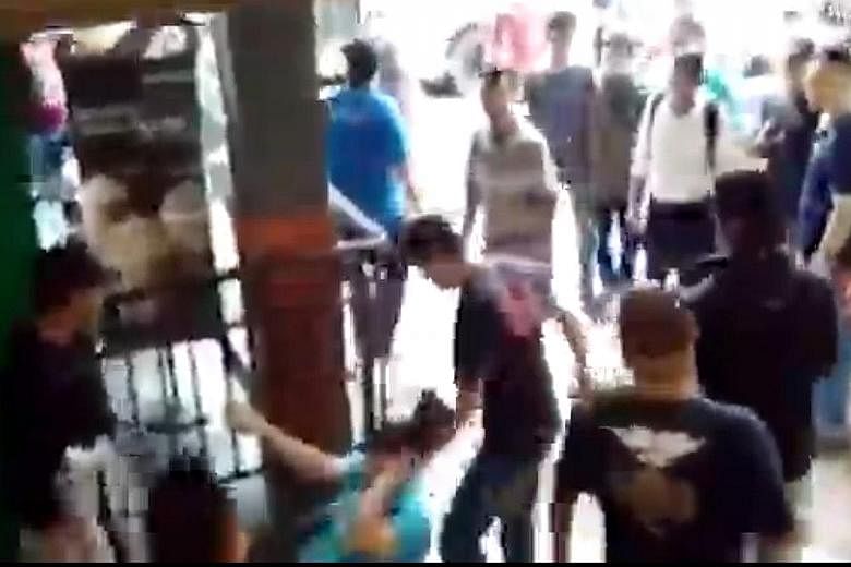 A phone seller (in light blue top, on the ground) being beaten up at Kota Raya mall on Sunday. Some 20 Malay men attacked cellphone sellers in the mall after allegations that a store had cheated a Malay customer.