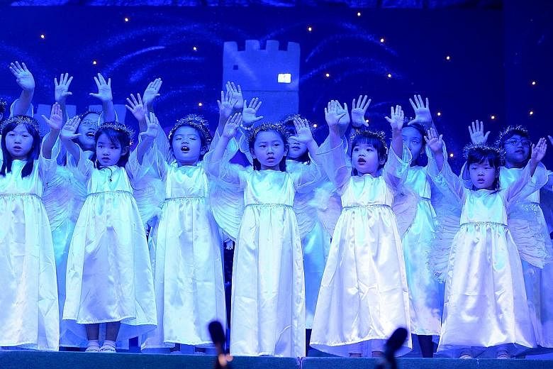 Sunbeams Children's Choir at Wesley Methodist Church on Wednesday. Many people were out shopping before Christmas, taking in decorations like the fairy tale-themed tree at Raffles City mall (below). Lemurs hunting for food in a Christmas tree-shaped 