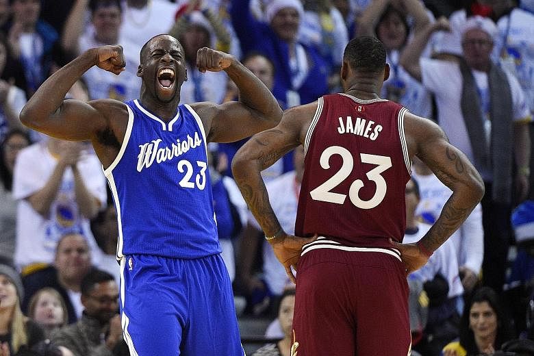 Draymond Green (in blue) is jubilant that his Golden State Warriors managed to stave off a late charge from the LeBron James-led Cleveland Cavaliers.