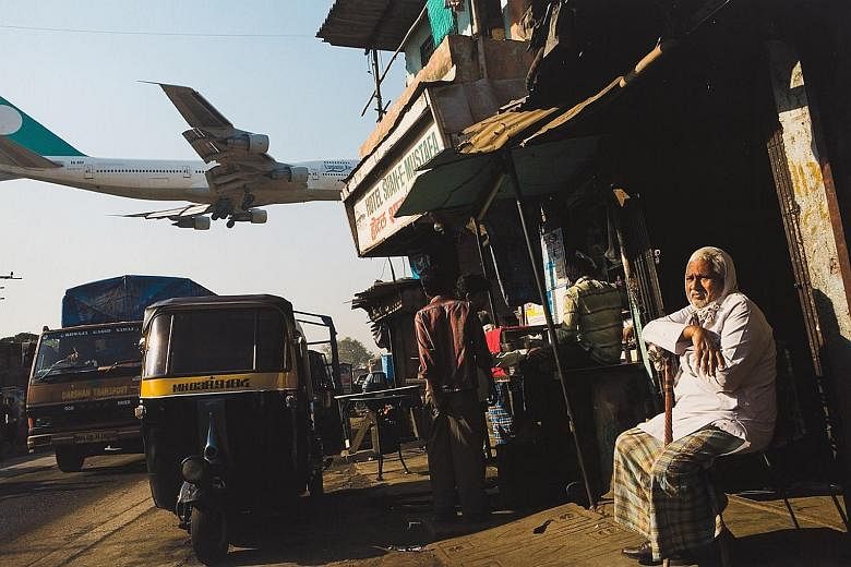 Above the Jari Mari slum in Mumbai, India, a plane prepares for landing (2008) by Adam Ferguson.