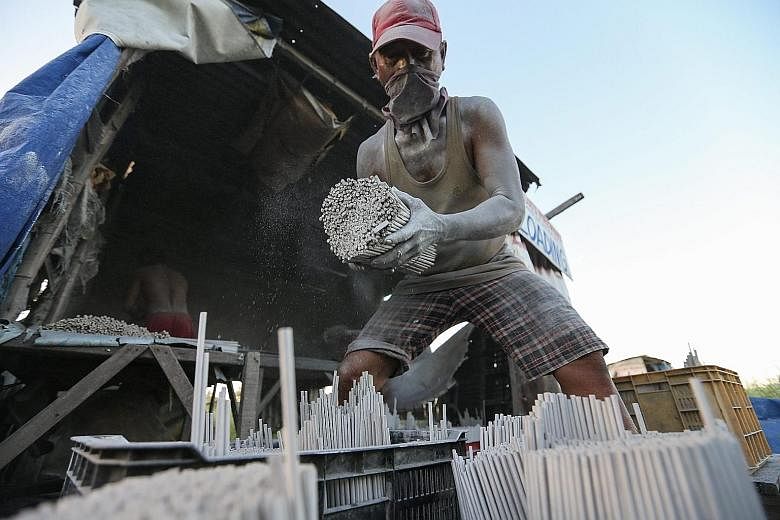 A Filipino worker loading firecrackers in a backyard factory in Bulacan, north of Manila, yesterday. The country's Department of Health has reported more than 50 injuries related to the use of firecrackers from last Monday to Saturday, with the numbe