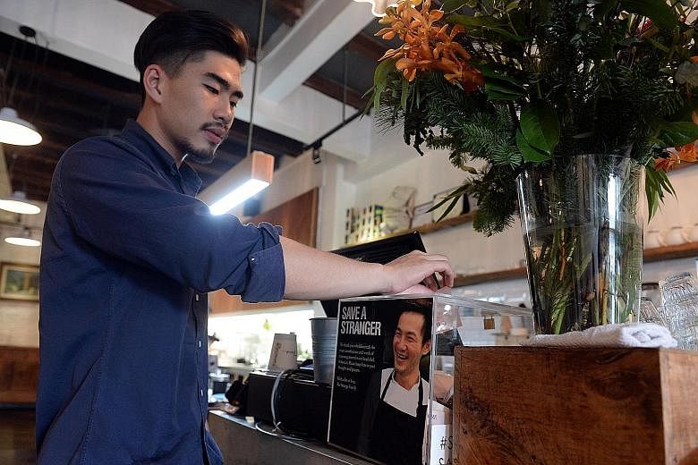 Patron Dylan Tan, 22, making a donation at Strangers' Reunion Cafe.