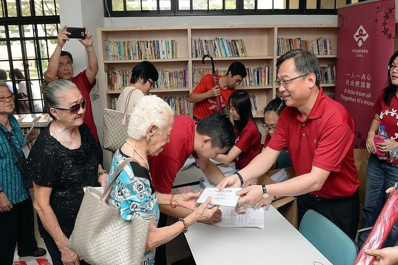 Mr Gan presenting Jubilee packs to low-income residents at CDAC@Bukit Panjang yesterday.