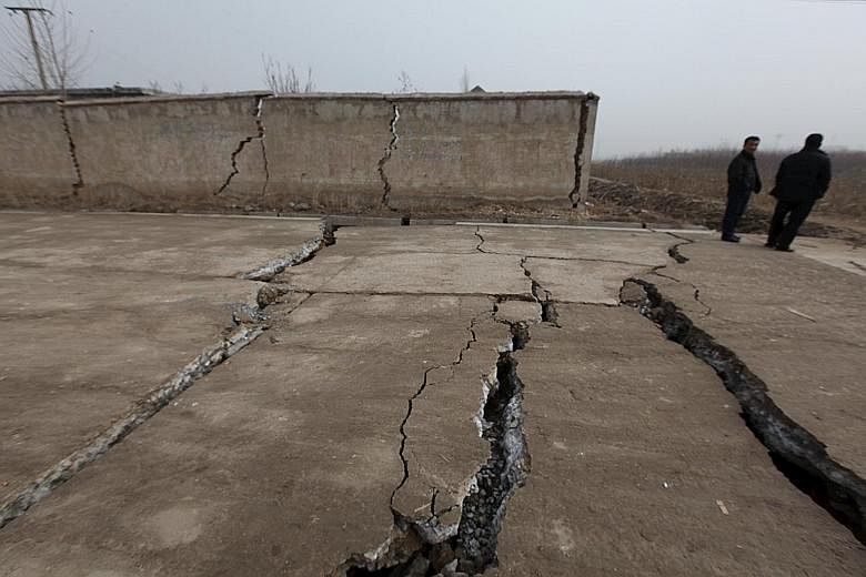 Cracked walls and pavements at the Shandong gypsum mine that caved in on Friday, killing one person and trapping 17. Rescue workers trying to reach survivors yesterday after having drilled a hole through the debris at the Shenzhen industrial park. Mo