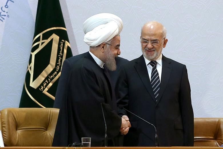 Iranian President Hassan Rouhani (left) shaking hands with Iraqi Foreign Minister Ibrahim Jafari during the 29th International Islamic Conference on Dec 27.