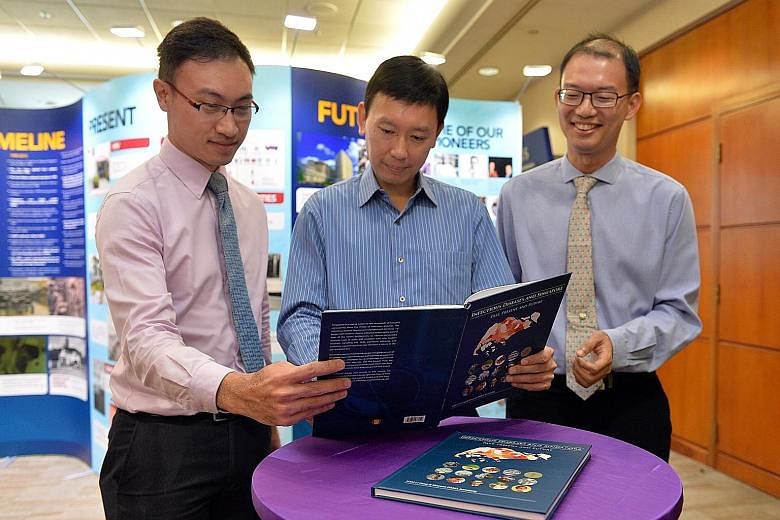 Authors Vincent Pang (left) and Hsu Li Yang (right) with Minister of State for Health Chee Hong Tat at the launch of an SG50 book on Singapore's experience in overcoming infectious diseases.