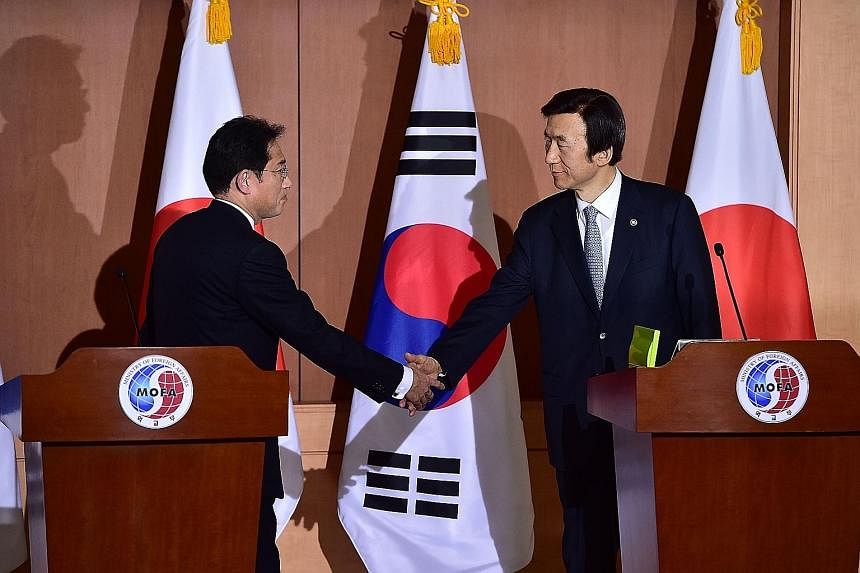 Japan's Foreign Minister Fumio Kishida (far left) and his South Korean counterpart Yun Byung Se after a joint press briefing in Seoul yesterday. Amnesty International said the agreement should not mark the end of the road in securing justice, as some