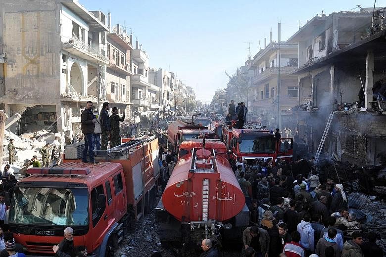 Fire engines at the site of two car bomb attacks in the Al-Zahraa neighbourhood in Homs yesterday. The attack came less than three weeks after the Islamic State in Iraq and Syria militant group claimed responsibility for explosions in the same neighb