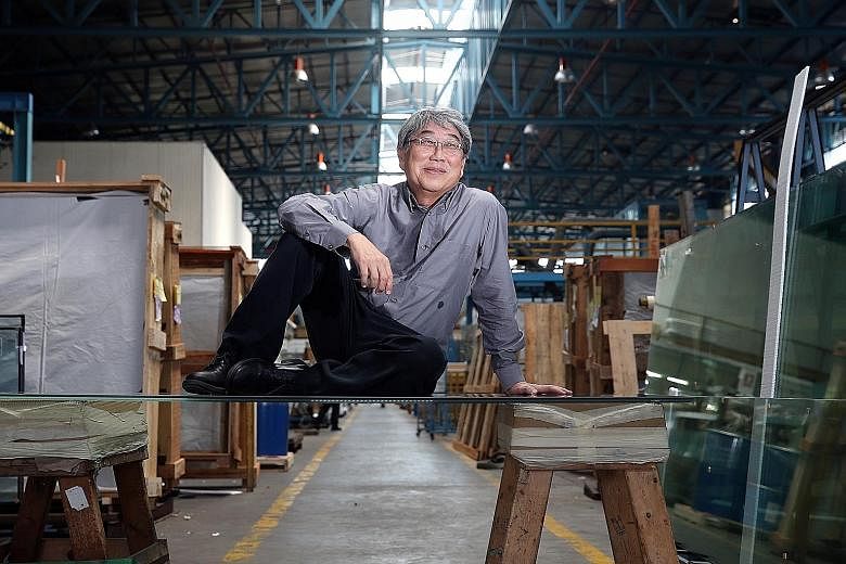 Mr Gan, seen here sitting on laminated heat-strengthened glass, plans to introduce thermochromic glass, an American technology, to Asia. This type of glass heats up and turns dark when the sun shines on it, cutting down the glare.
