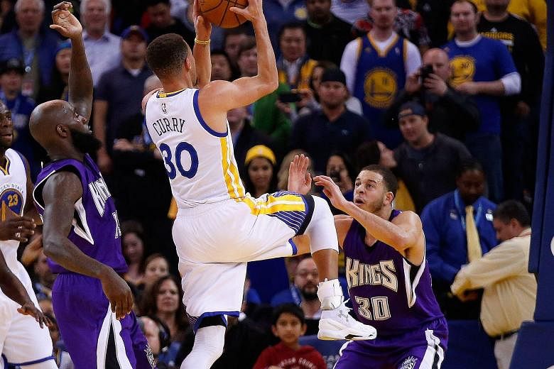 Stephen Curry (left) shooting over his younger brother Seth of the Sacramento Kings during the Golden State Warriors' 122-103 win at Oracle Arena on Monday.