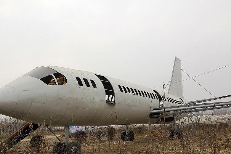 Children playing in a "homemade" Boeing 737 replica in a crop field in Neihuang county, China's Henan province, on Sunday. Farmer Wang Lanqun spent a year making the 35m-long installation, and there are plans to transform it into a restaurant, accord