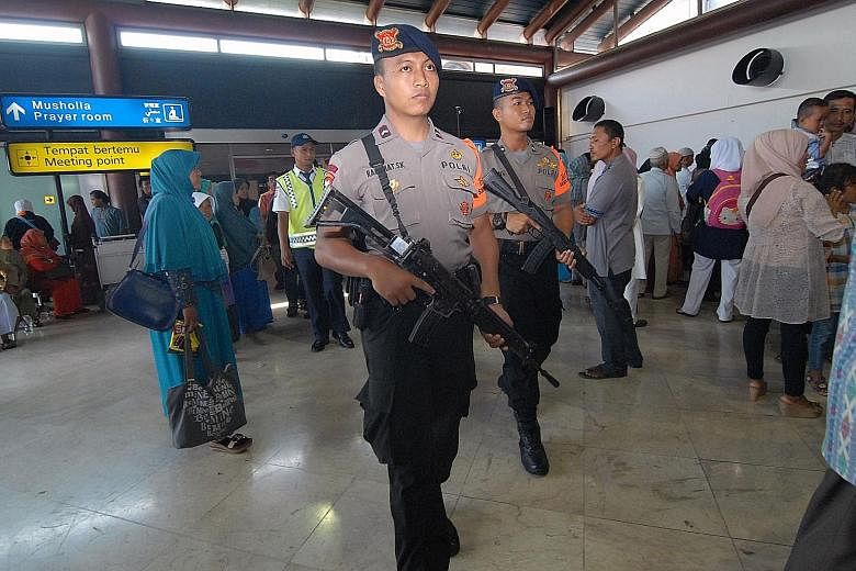 Indonesian police officers patrolling at Jakarta's Soekarno-Hatta airport yesterday. Officials say security has been ratcheted up for New Year's Eve this year in more than just the capital cities, following terrorist attacks in cities around the worl