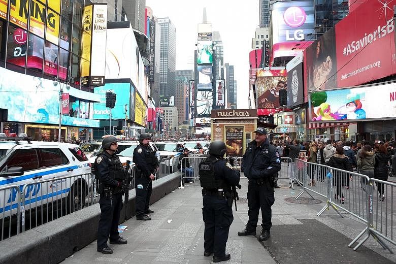 Police officers on patrol on Sunday in New York City's Times Square (above), where up to one million party-goers are expected to ring in the new year. Thousands of officers will be on patrol there, and a new unit of 500 police officers trained to wor