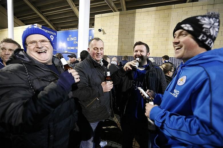 Leicester City fans with their free bottles of beer before the Man City match.