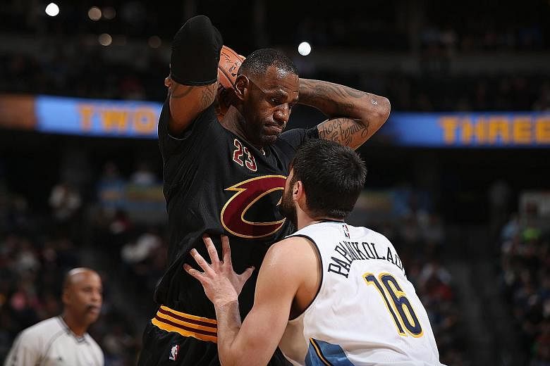 LeBron James controlling the ball against Denver's Kostas Papanikolaou (right). The Cleveland star scored 34 points on the eve of his 31st birthday.