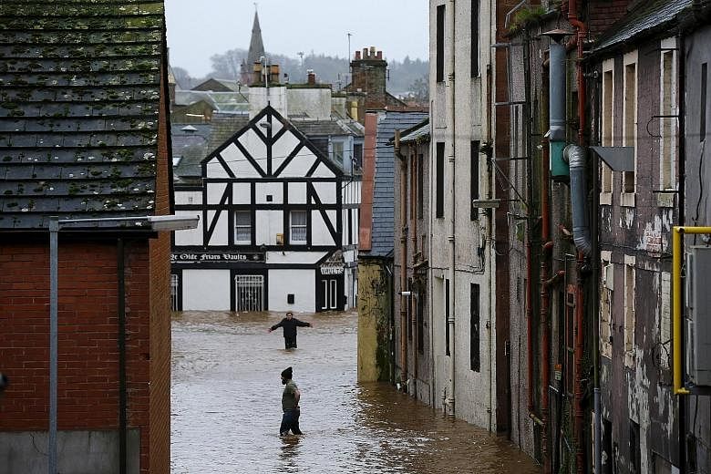 A flooded street in Dumfries, Scotland, on Wednesday as torrential rain and gale force winds battered northern Britain, cutting power to thousands of homes.